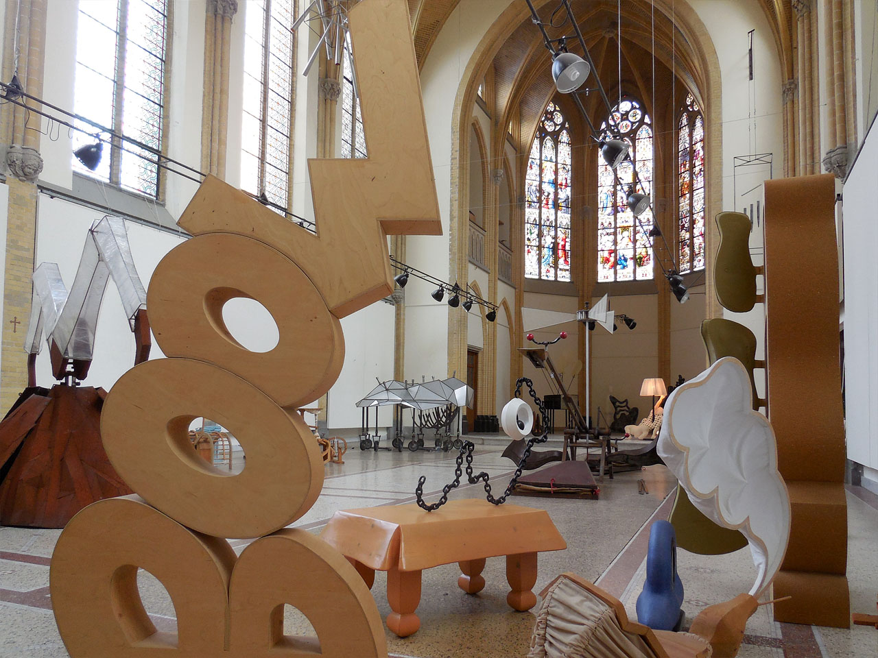 Tentoongestelde objecten in een ruime en hoge neogotische kapel.